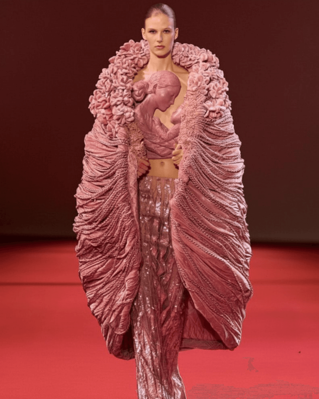 An Ode to Motherhood - The sculptural bodice pays tribute to the bond between mother and child, elevated through intricate craftsmanship and dramatic, cocoon-like draping.